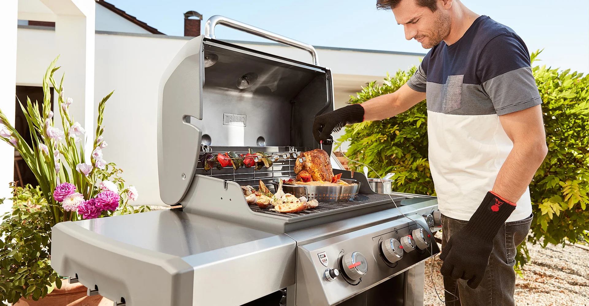 Mann grillt am Edelstahl-Gasgrill im Garten