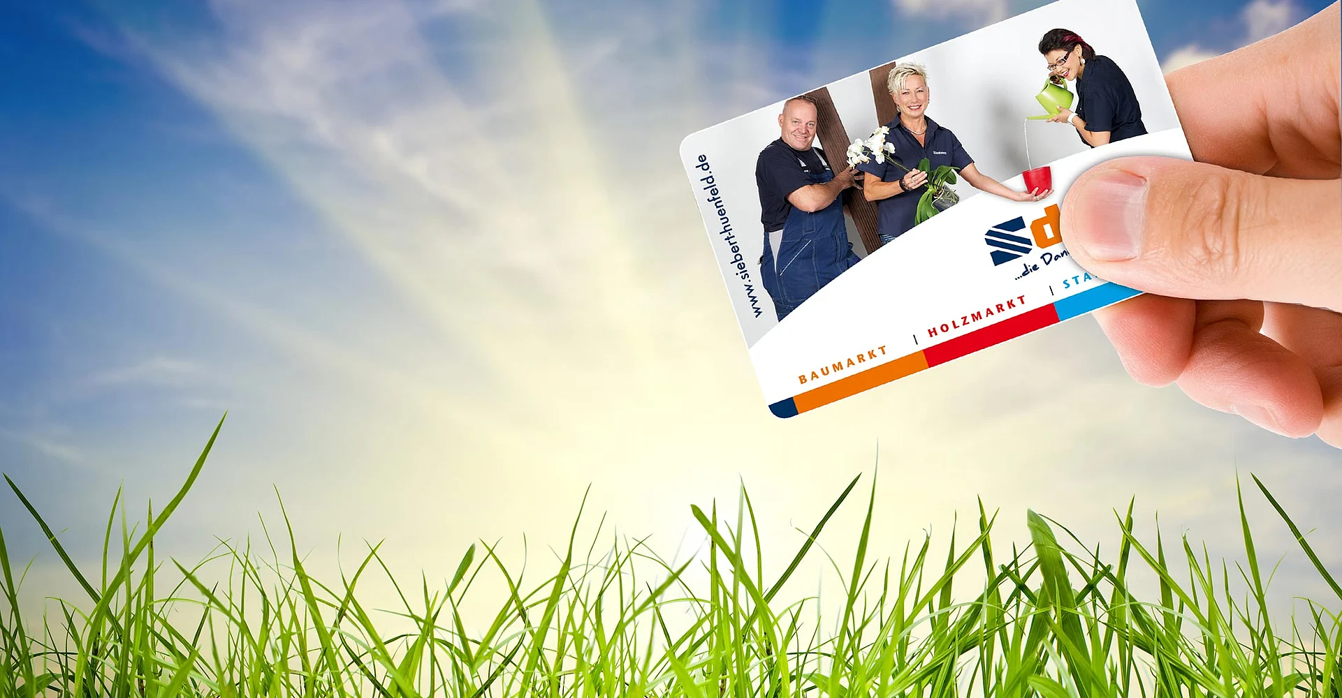 Sdrei-Kundenkarte in der Hand vor Sommerwiese