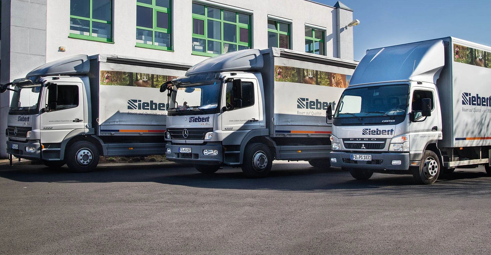 Drei Lkw der Siebert Lieferflotte vor dem Markt
