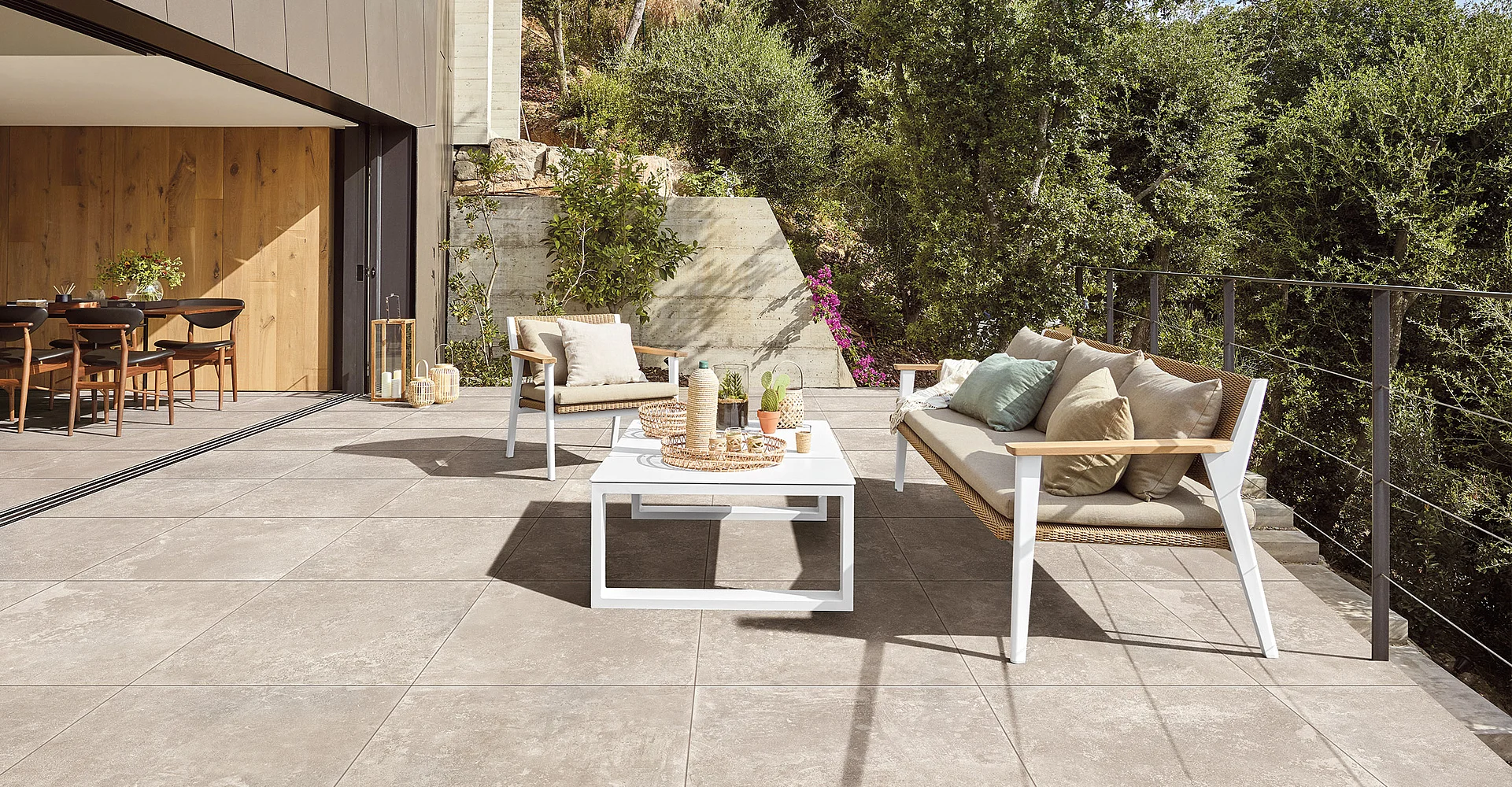 Terrasse mit großen Keramikplatten und Gartenmöbeln