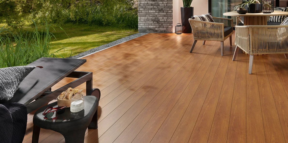 Holzterrasse mit Lounge-Möbeln vor dem Haus