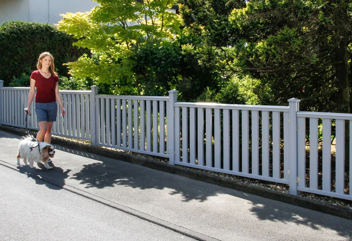 Weißer Gartenzaun an einem Gehweg